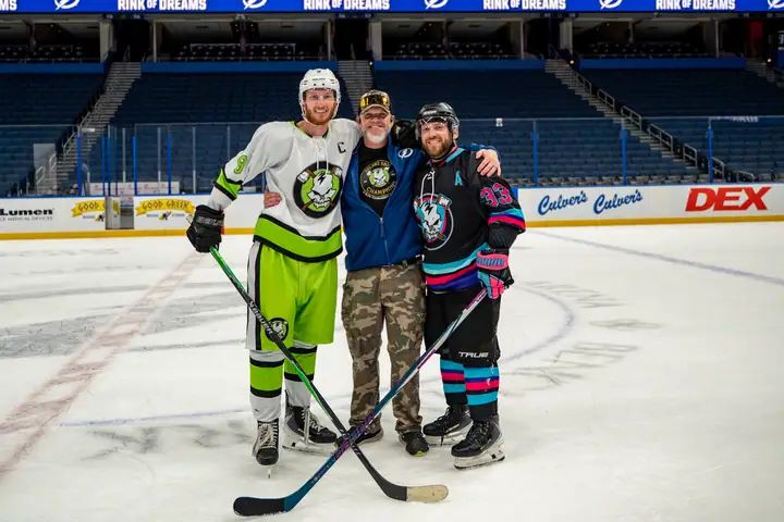 Three players posing together at center ice