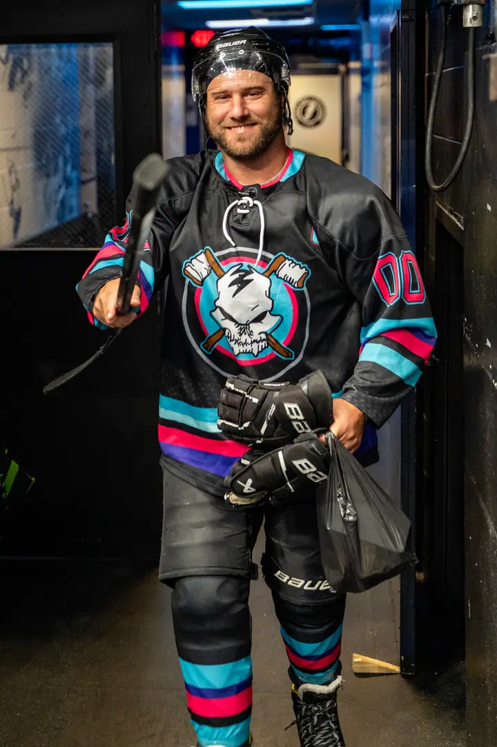A Stick N Bones player grinning on his way out of the tunnel