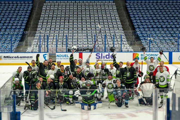 Stick N Bones players raising their sticks for a group photo at the Rink Of Dreams